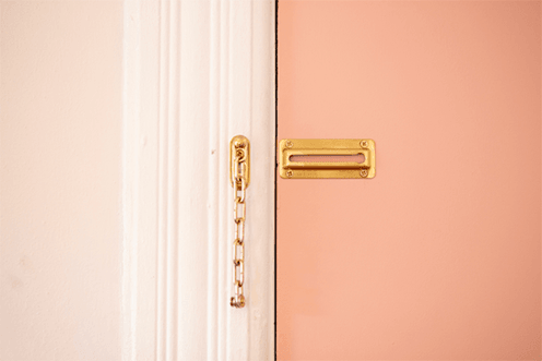 Pink door with gold chain lock