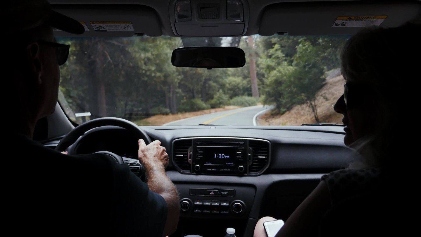Two people driving in a car in the countryside Two people driving in a car in the countryside