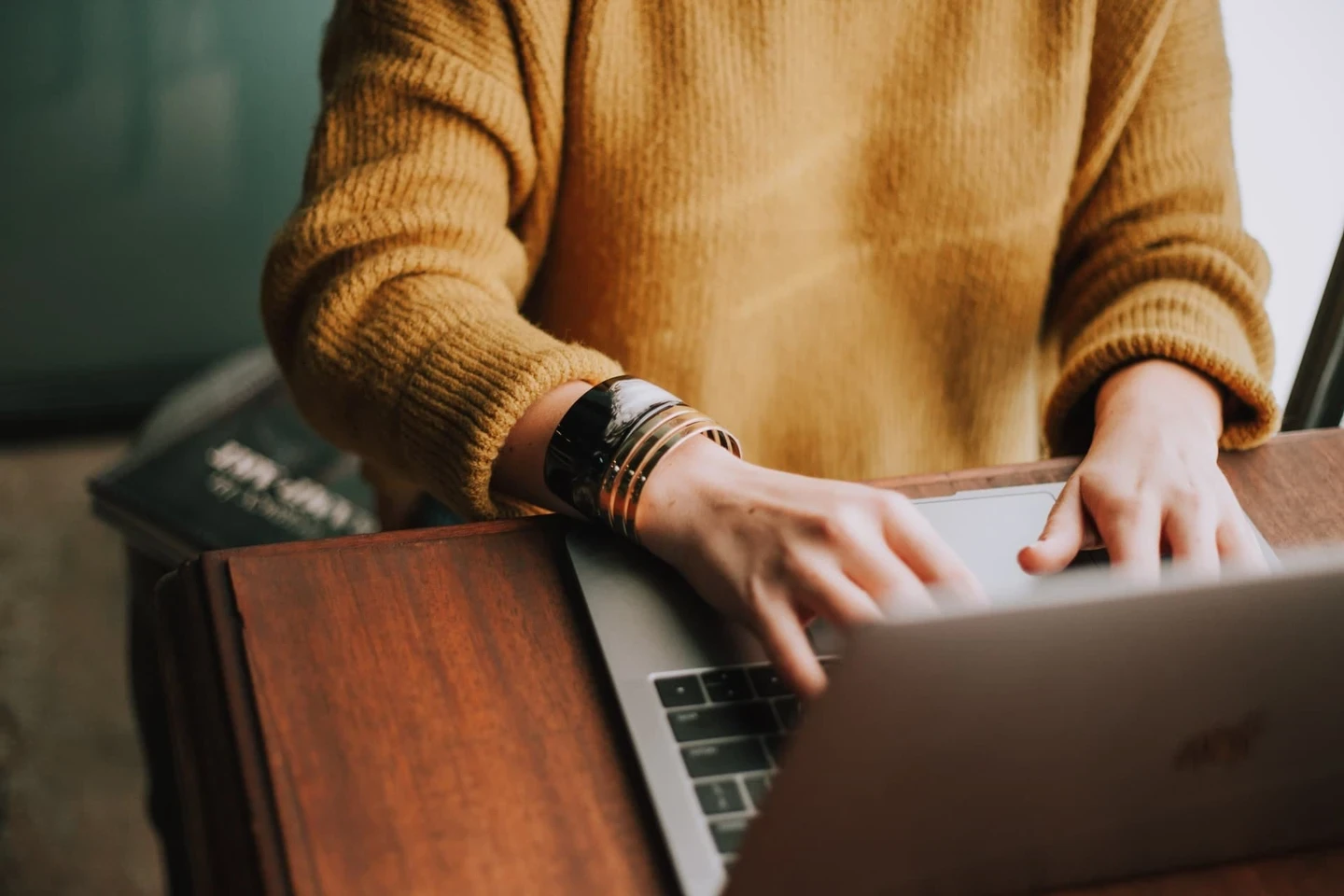 Woman in orange jumper on laptop Woman in orange jumper on laptop