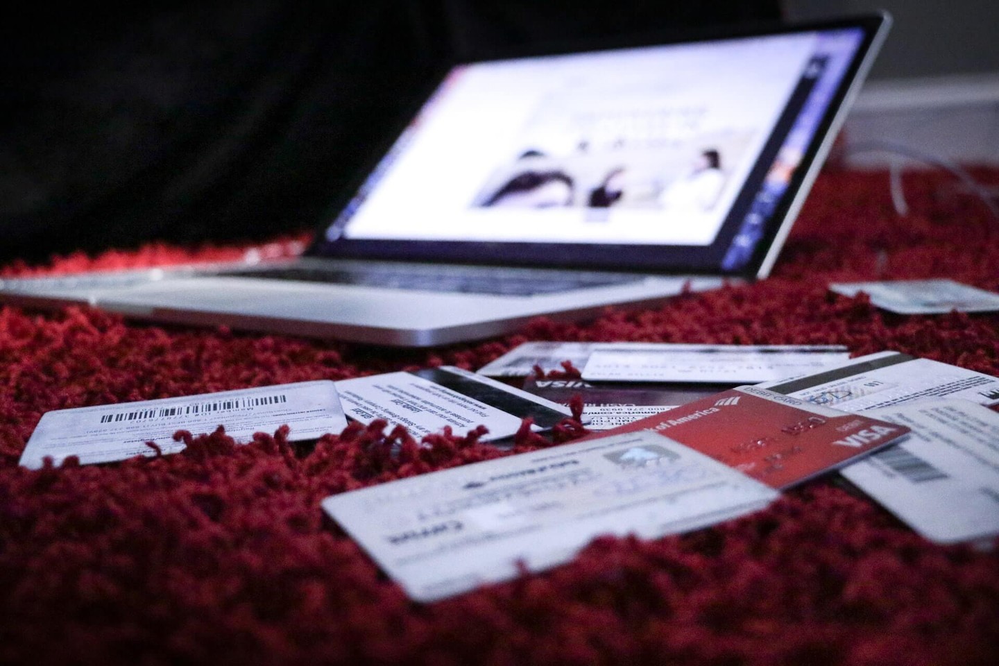 Laptop and credit cards on a red surface