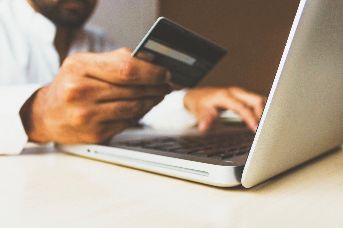 Man with laptop holding a credit card 