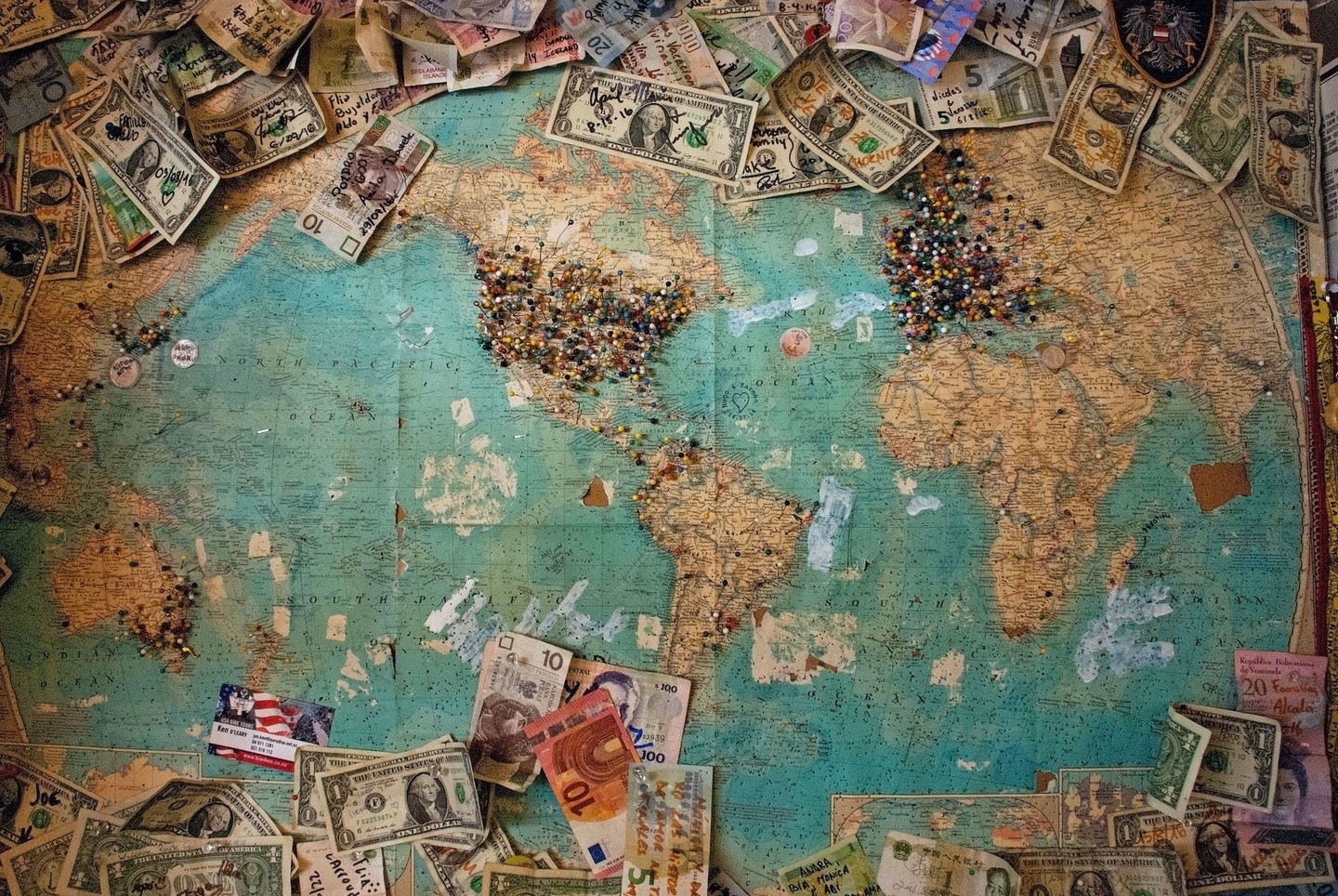 World map with different countries' currencies spread on it