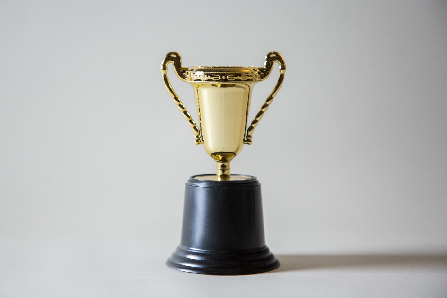 A gold trophy on a grey background