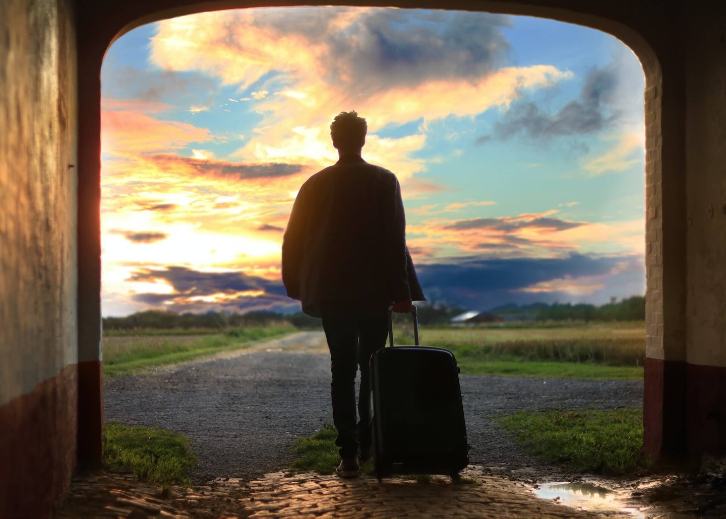 Person with a suitcase walking out of a doorway