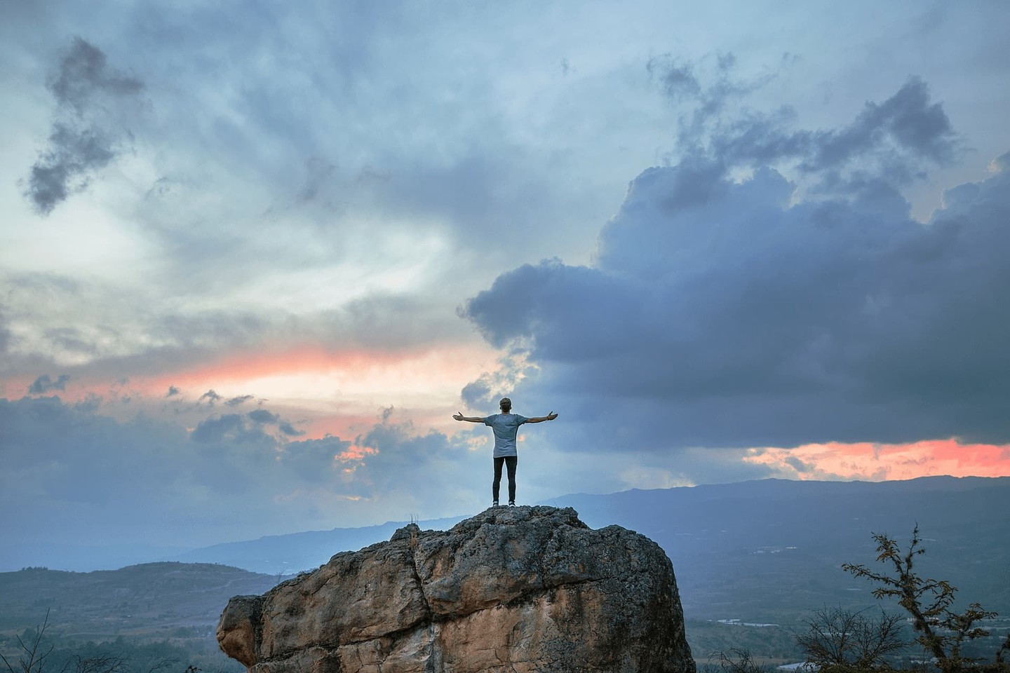 Man standing on rock with clouds in sky