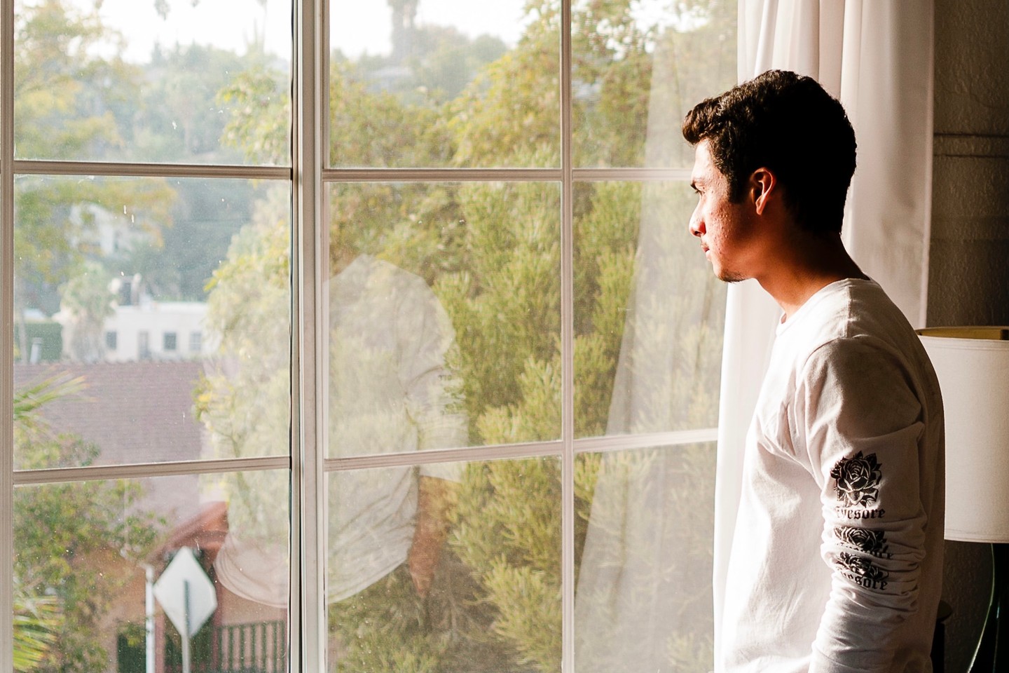 man looking out of a window at trees