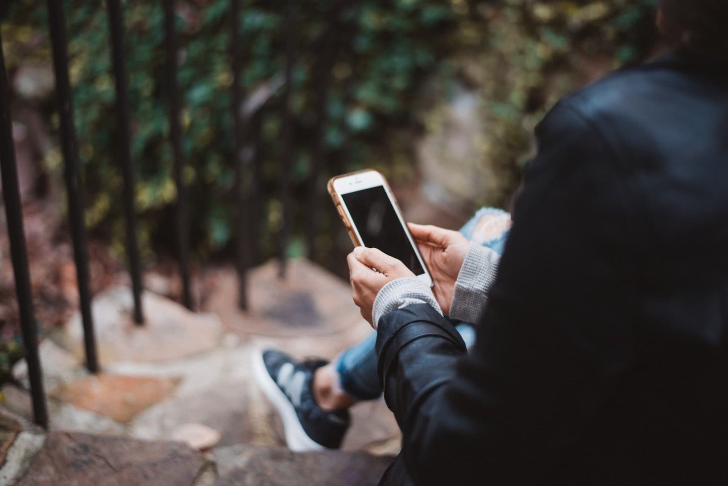 Woman checks her phone on outdoor stairs