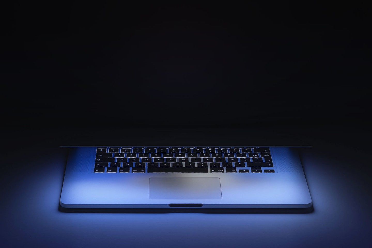 Laptop glowing in a dark room 
