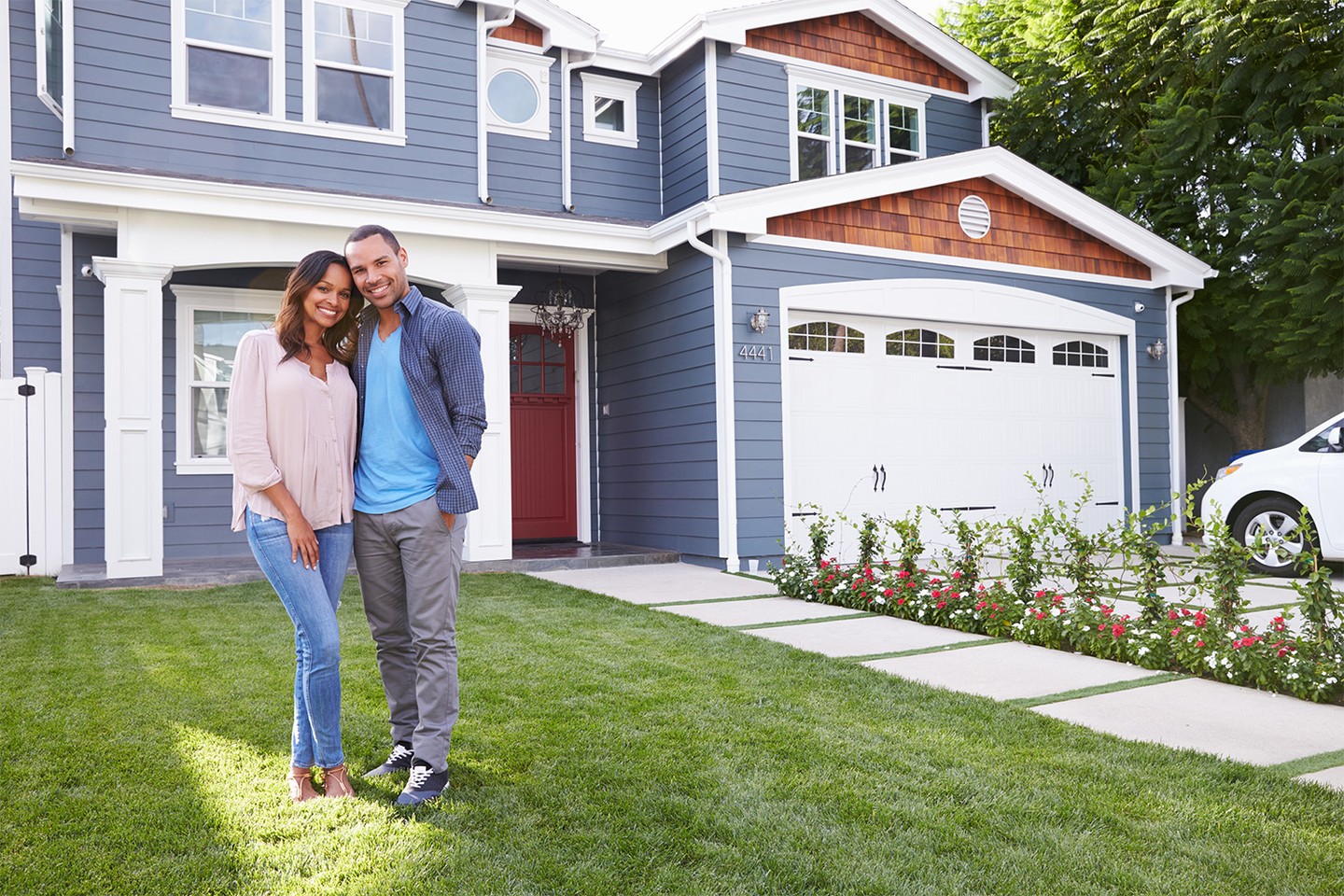 Happy couple standing outside their house Happy couple standing outside their house
