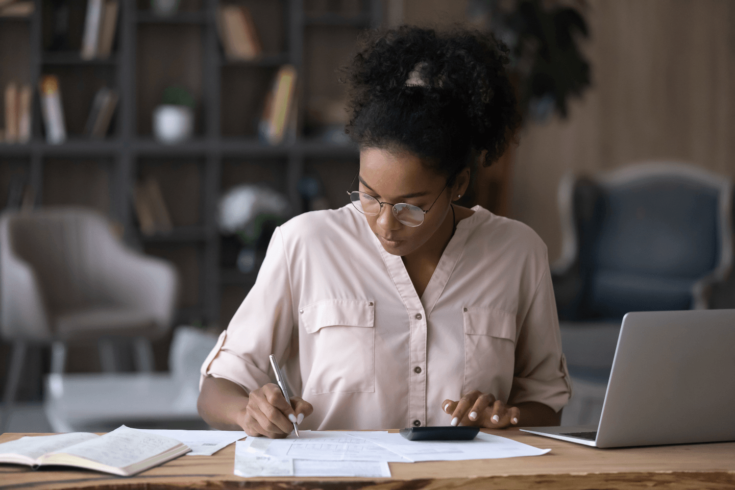 Woman does calculations while sitting at a desk