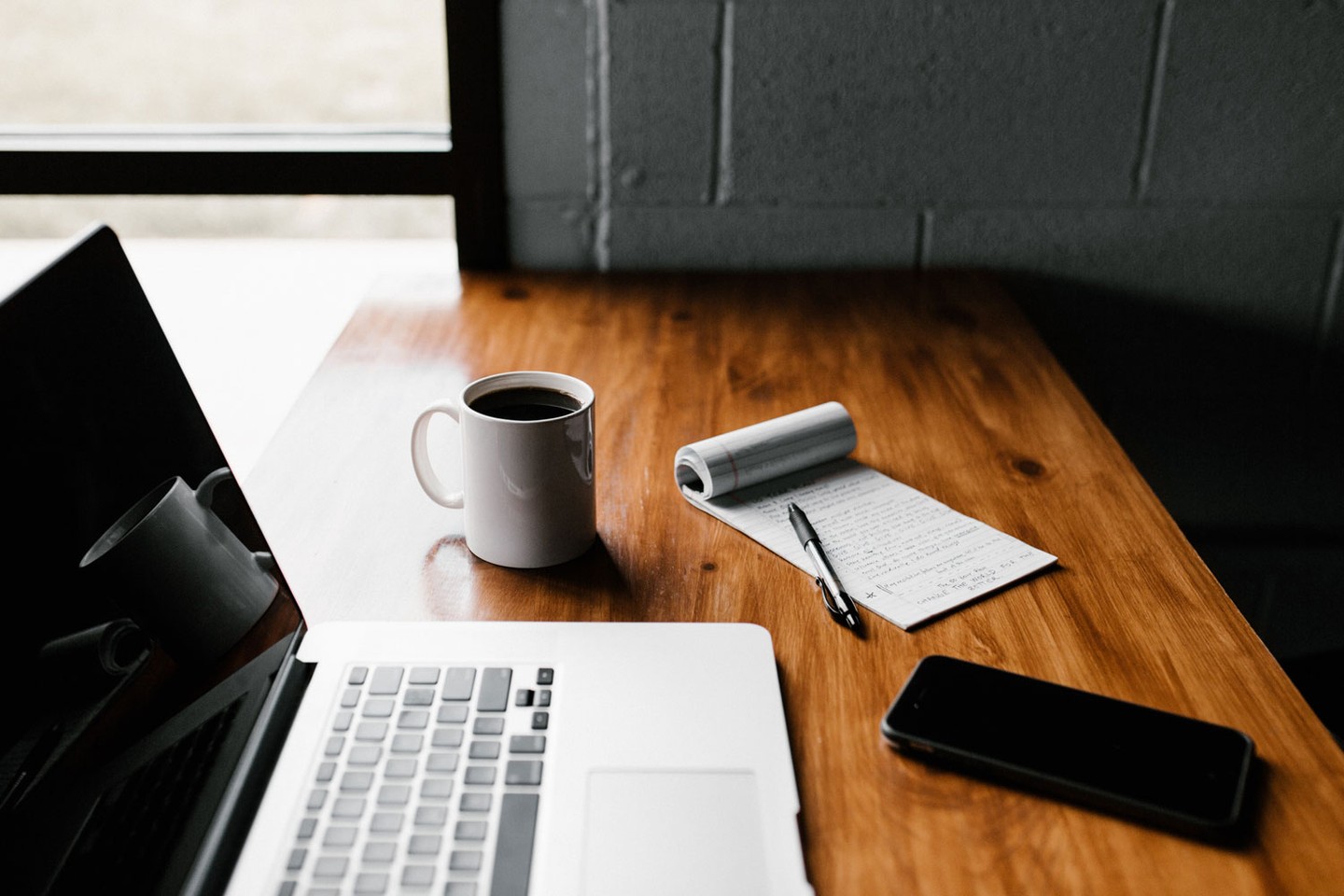 Notepad and laptop on desk