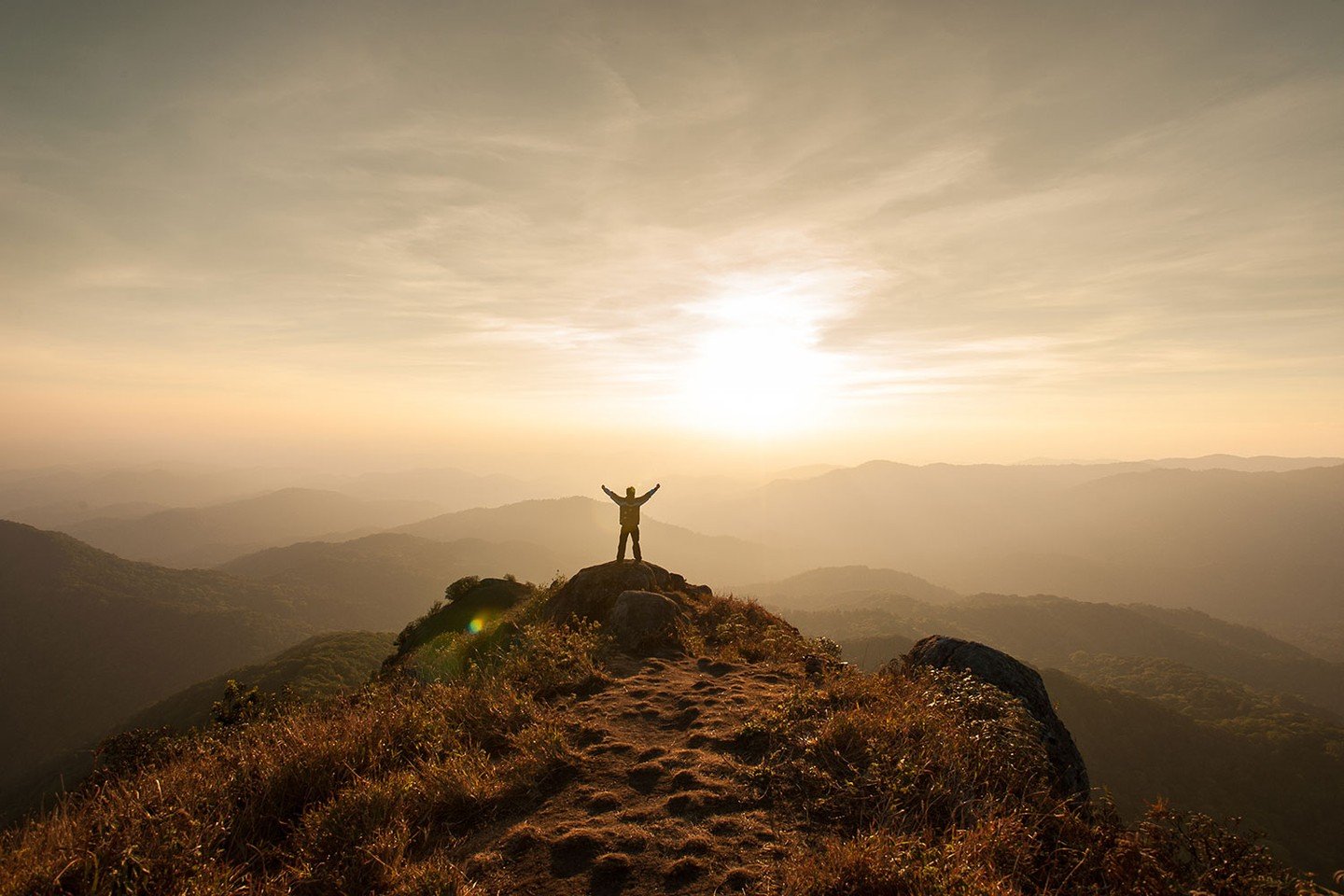 Man standing in victory on mountain
