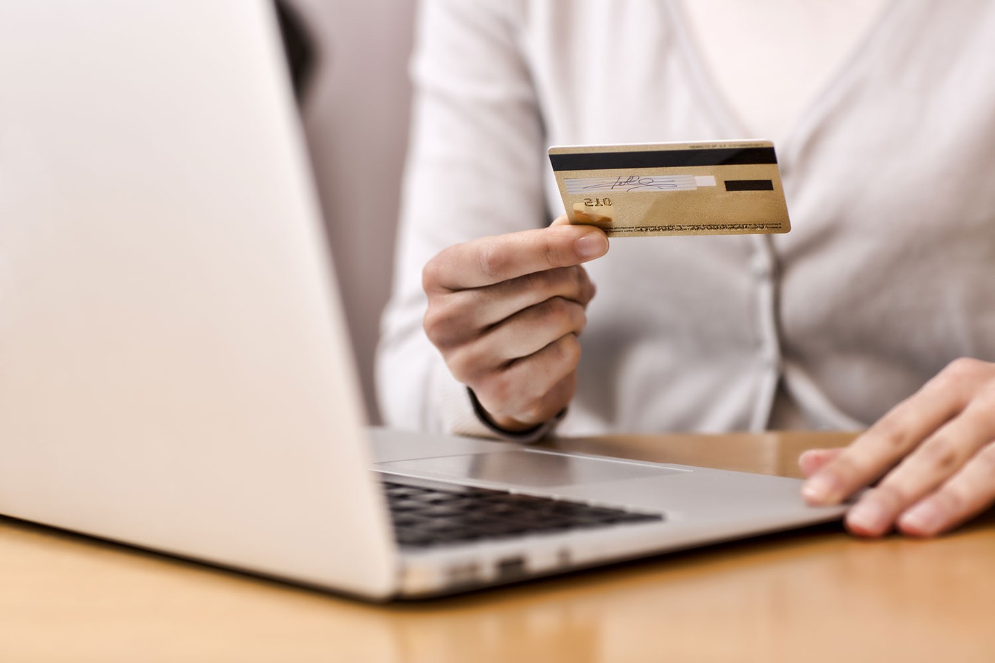 Holding credit card near laptop Holding credit card near laptop