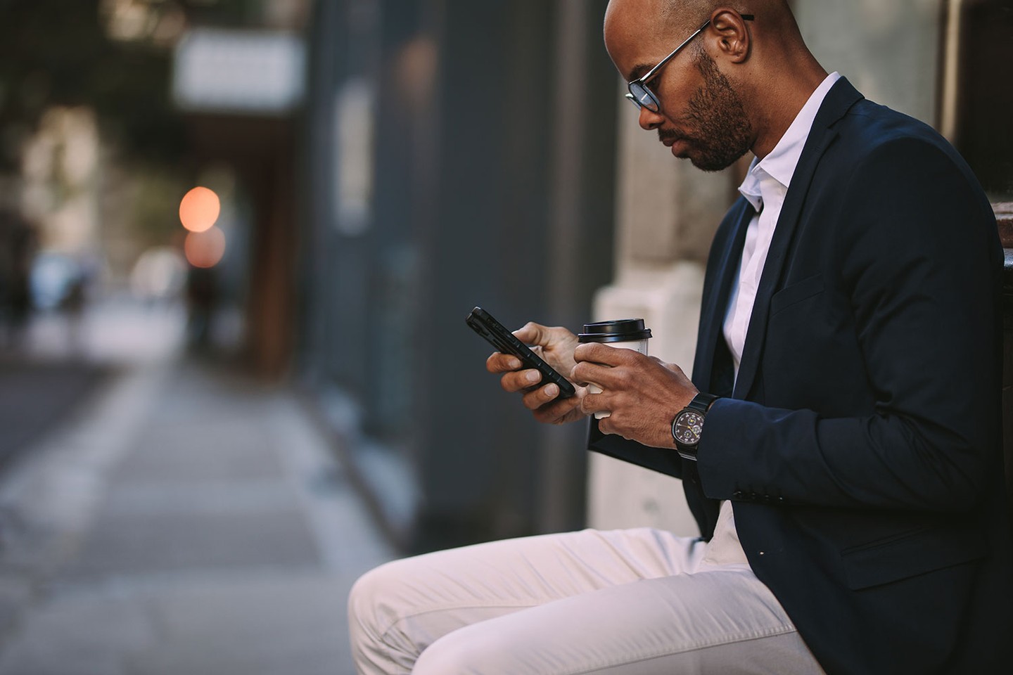Man looking at phone with coffee Man looking at phone with coffee