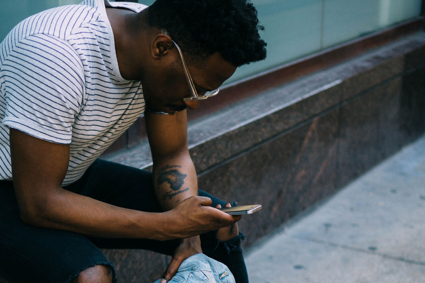 African man looking down at phone